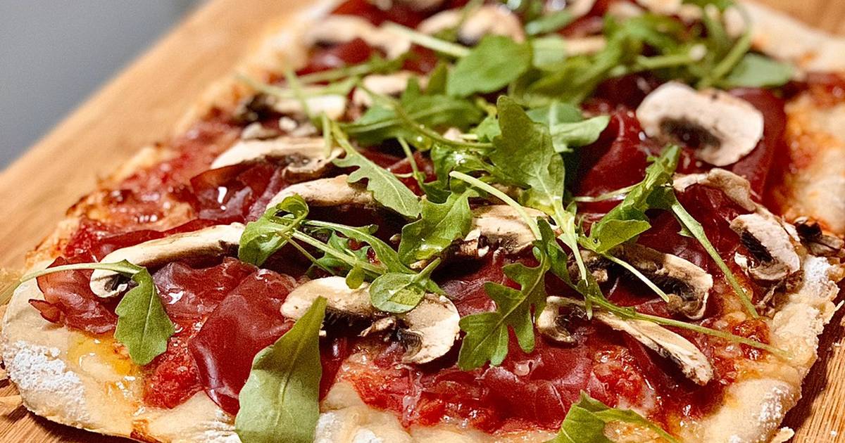 Pizza de bresaola, rúcula y aceitunas