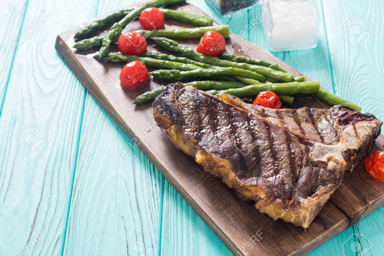 Chuletón de buey a la parrilla con espárragos al horno